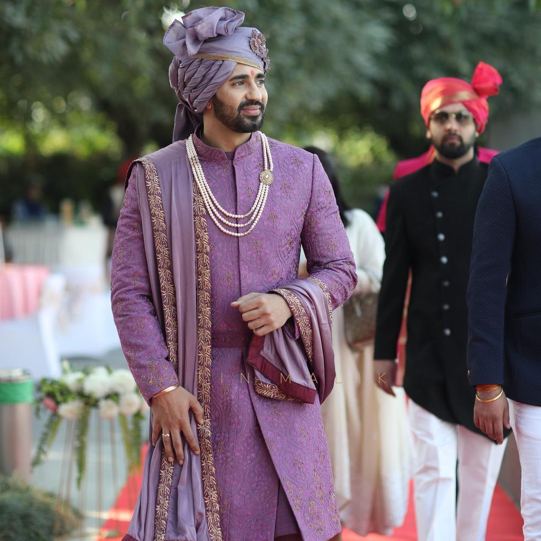 groom wearing purple sherwani